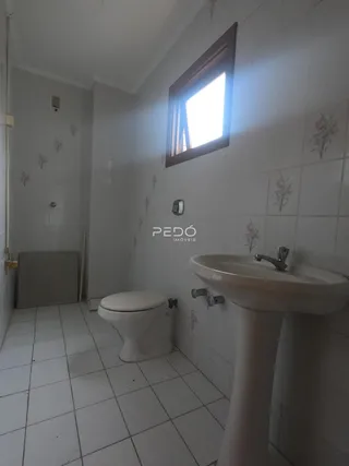 Foto de um banheiro com piso de cerâmica e azulejos brancos.