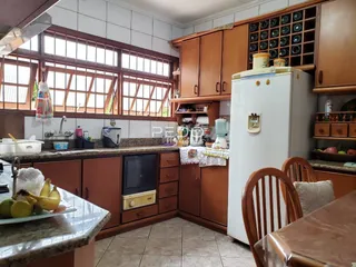 Foto de uma cozinha com armários de madeira e janelas grandes.