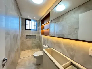 Foto de um banheiro com revestimento de azulejos e louças brancas.