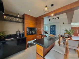 Sala de estar e cozinha com painel de madeira e ilha moderna.