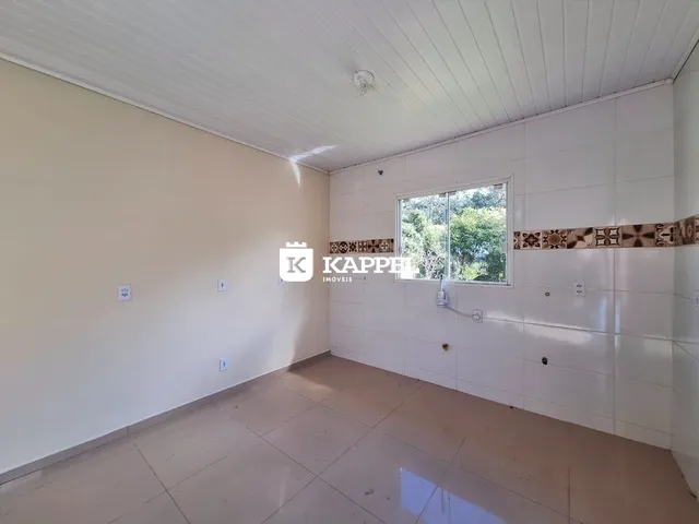Foto de uma sala de estar com paredes brancas e piso claro.