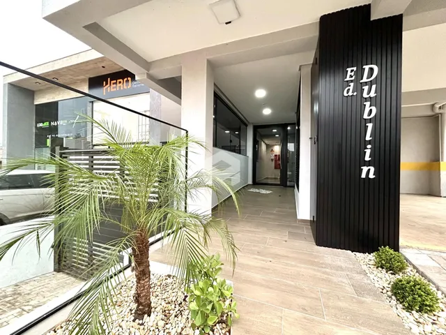 Hall de entrada moderna com piso de madeira e vegetação.