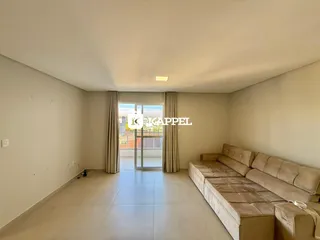 Uma sala de estar ampla com piso de cerâmica e acesso a uma área externa.