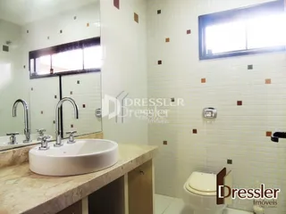 Foto de um banheiro com revestimento de azulejos brancos e pia.