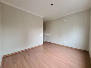 Ambiente interno de uma sala com piso de madeira clara.
