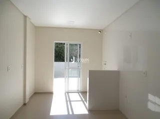 Foto de um ambiente interno com paredes brancas e piso claro.
