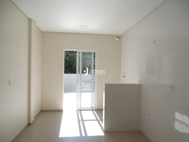 Foto de um ambiente interno com paredes brancas e piso claro.