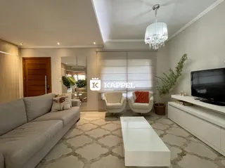 Sala de estar moderna com sofá cinza e televisão em ambiente claro.