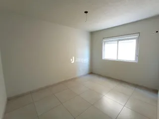 Uma sala com paredes brancas e piso de cerâmica clara.