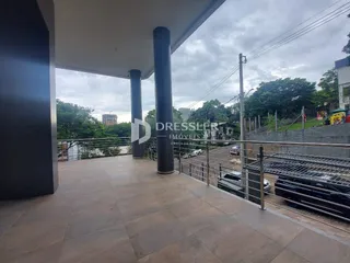 Vista de uma área externa pavimentada com grade de proteção.