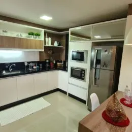 Foto de uma cozinha com armários brancos e bancada.