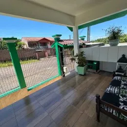 Sala com piso de madeira e vista externa.