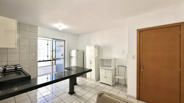 Vista interna de uma cozinha com piso de cerâmica e portas de vidro.