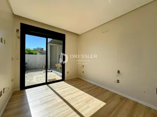 Vista interna de uma sala com porta de vidro que dá acesso ao exterior.