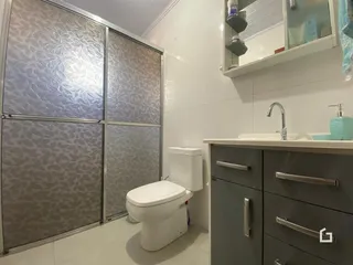 Foto de um banheiro com revestimento cerâmico e armários modernos.