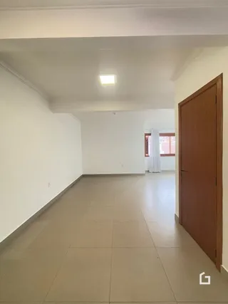 Hall de entrada com piso de cerâmica claro.
