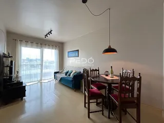 Sala de estar com sofá e mesa de jantar em um imóvel no Brasil.
