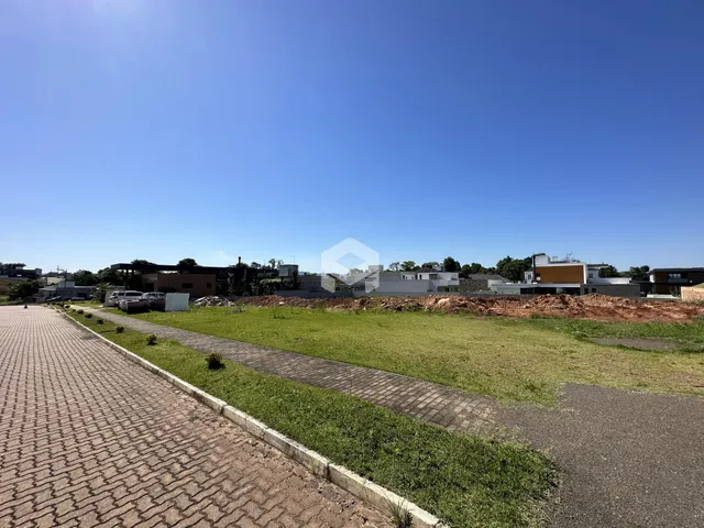 Vista externa de um terreno com gramado e área pavimentada.