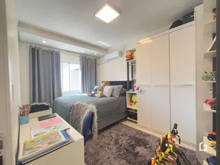 Foto de um quarto com cama e armários brancos em um imóvel.