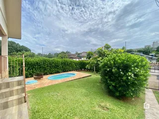 Vista do quintal com piscina e gramado.