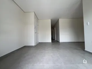 Corredor interno de um imóvel com paredes brancas e piso cinza.