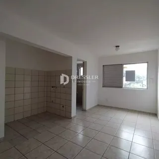 Interior de uma sala com piso de cerâmica clara e paredes brancas.