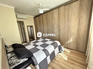 Quarto com cama e armário de madeira em um ambiente interno.