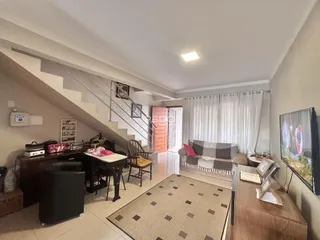 Sala de estar com escadaria e sofá em apartamento no Brasil.