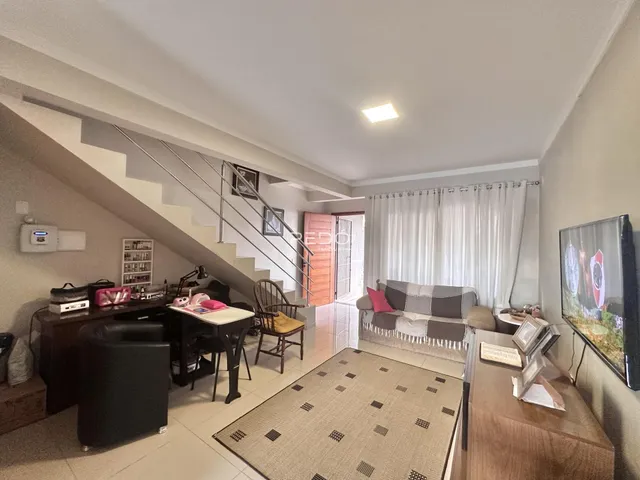 Sala de estar com escadaria e sofá em apartamento no Brasil.