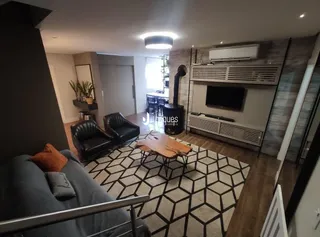 Sala de estar moderna com sofá e piso de madeira em um apartamento.