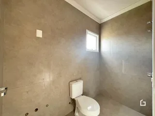Banheiro com paredes em tom neutro e janela.