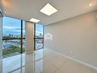 Sala de estar com grandes janelas que oferecem uma vista da cidade.