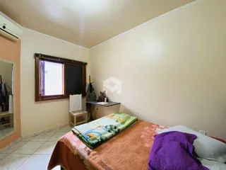 Quarto com cama e janela em ambiente interno.
