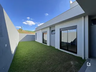 Fachada moderna de uma residência com jardim gramado.