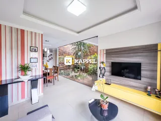 Sala de estar moderna com porta de vidro que dá acesso a um jardim.