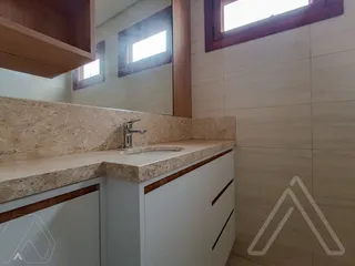 Foto de uma bancada de cozinha com pia e armários brancos em um ambiente interno.