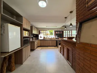Cozinha com armários de madeira e piso claro, apresentando uma área de trabalho bem iluminada.