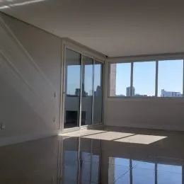 Vista de um ambiente interno com grandes portas de vidro que dão para a paisagem.