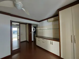 Vista de um corredor com piso de madeira e portas internas.