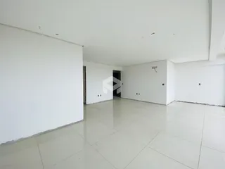 Interior amplo e vazio de uma residência com piso de cerâmica.