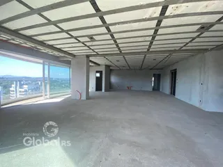 Espaço interno de um imóvel em construção com teto de concreto aparente.