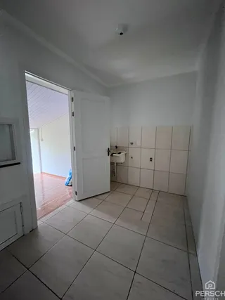 Hall de entrada com piso de cerâmica e paredes brancas.