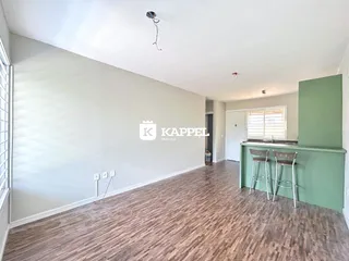 Ambiente interno com piso de madeira e paredes brancas em um imóvel.