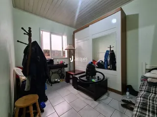Quarto com armário embutido e espelho na sala.
