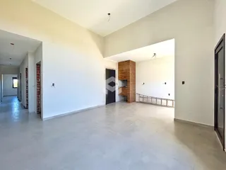 Interior de um espaço amplo com paredes brancas e piso claro.