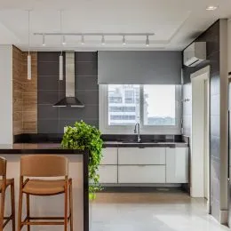 Cozinha moderna com armários brancos e bancada escura em um ambiente interno.