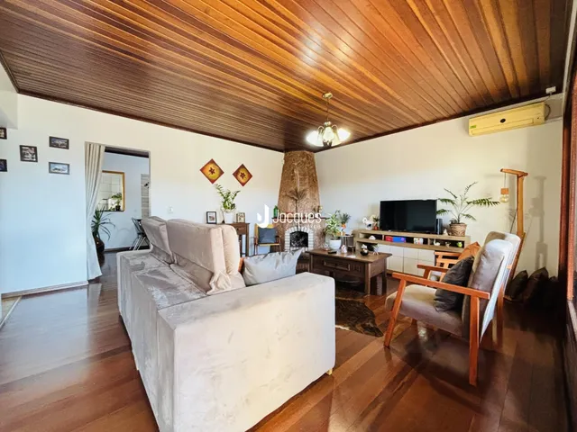 Sala de estar com piso de madeira e lareira em uma residência.