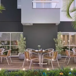 Varanda externa com deck de madeira e vegetação.