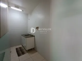 Vista interna de um ambiente com piso cerâmico e bancada de pia.