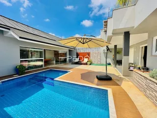 Vista externa de uma residência com piscina e área de lazer.